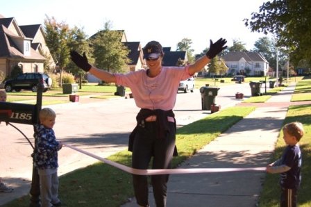 women-runner-crossing-finish-line-in-neighborhood